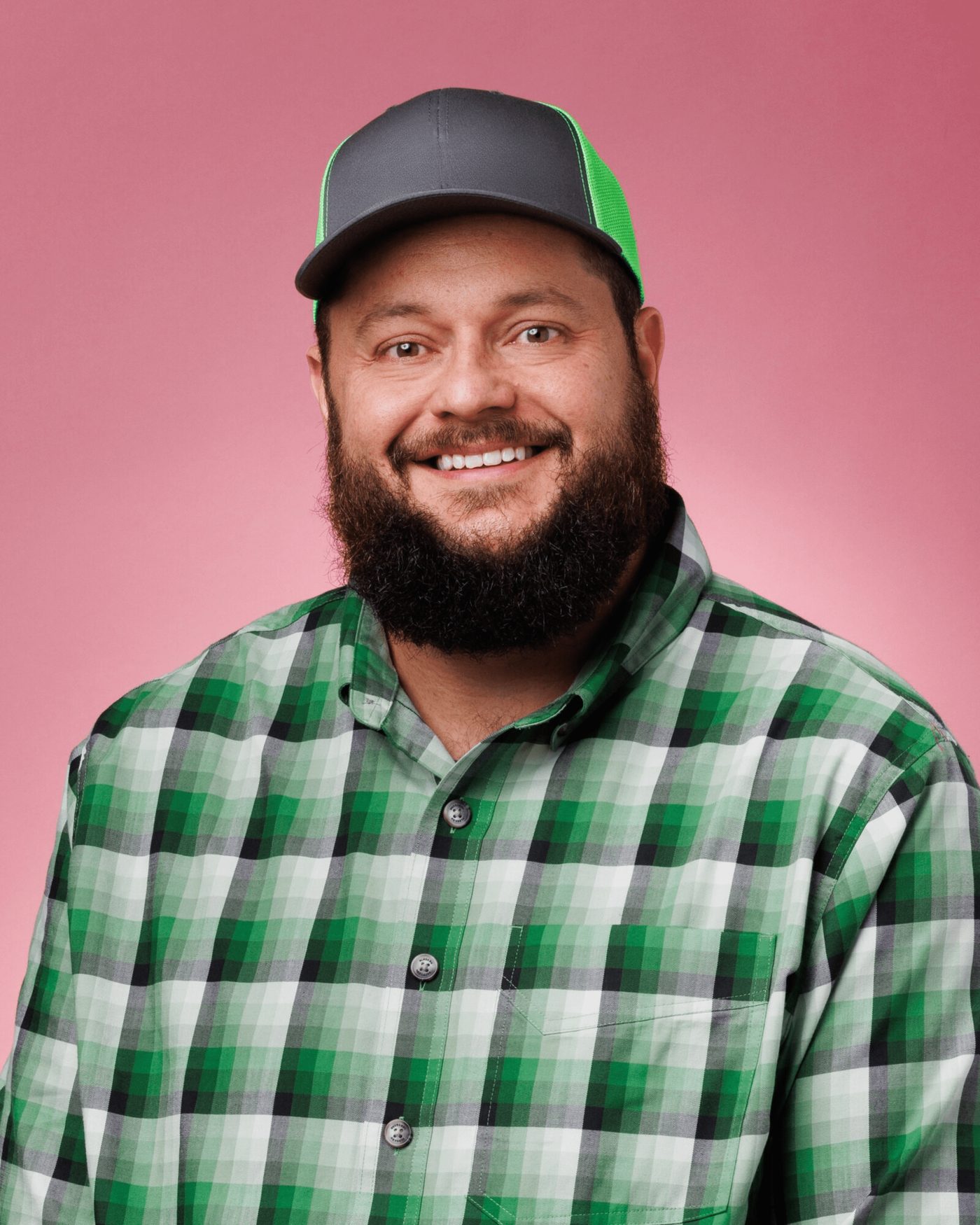 Carl Britton Jr. smiling in a ball cap and plaid shirt Carl Britton Jr. smiling in a ball cap and plaid shirt
