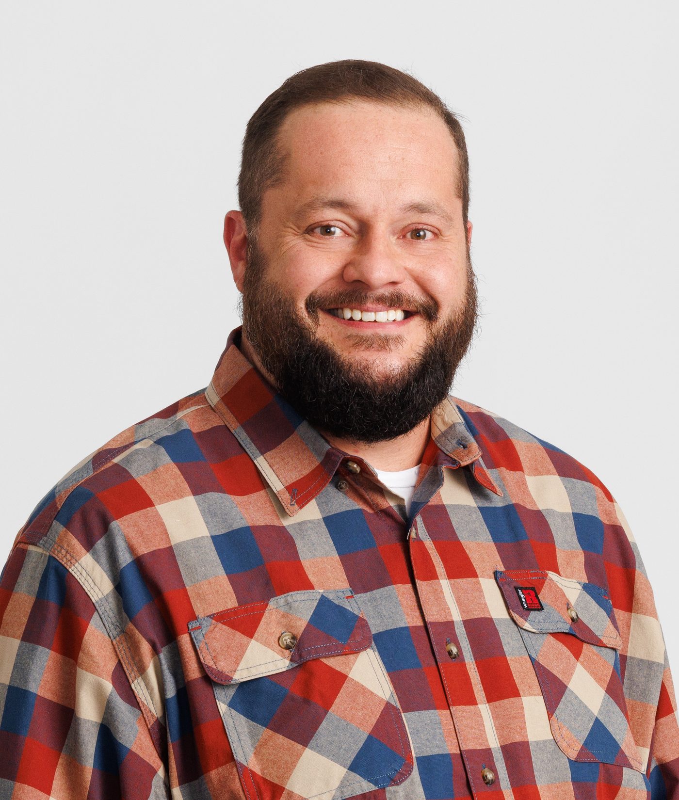 Carl Britton Jr., AI educator for construction contractors, in a plaid shirt against a light background Carl Britton Jr., AI educator for construction contractors, in a plaid shirt against a light background